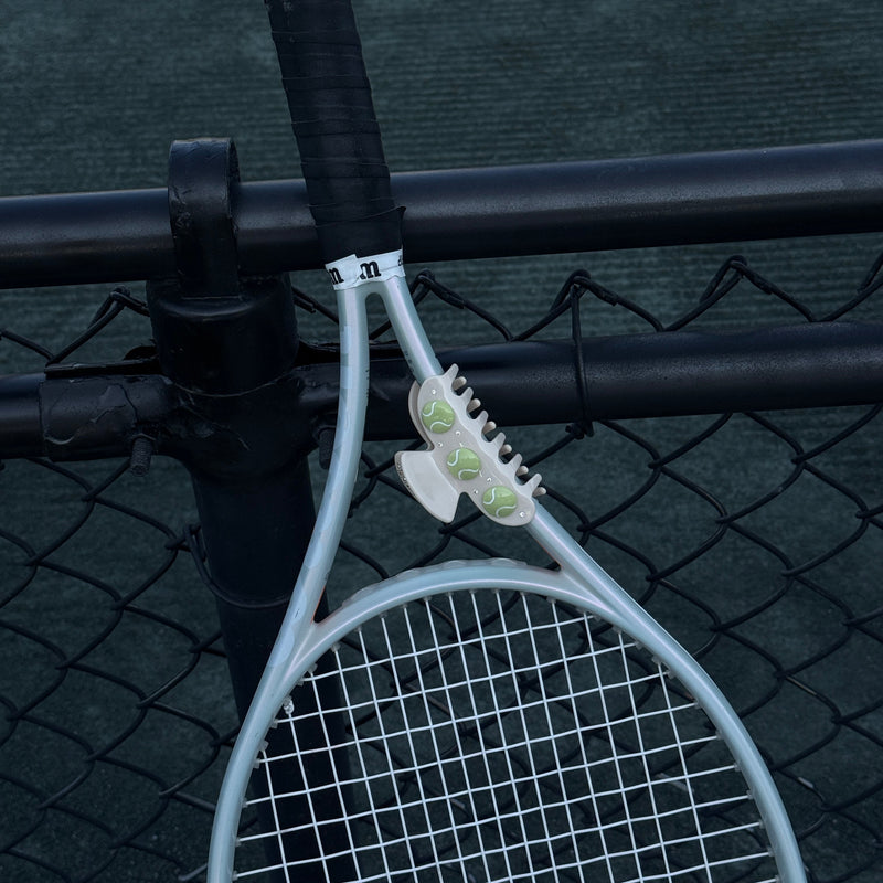 Tennis racket leaning against a tennis net on a tennis court